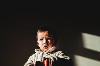 Close-up of boy sitting in darkroom