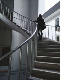 Rear view of woman climbing staircase