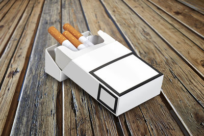 Close-up of cigarettes in pack on wooden table