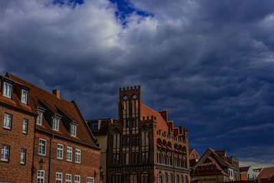 Low angle view of buildings against cloudy sky