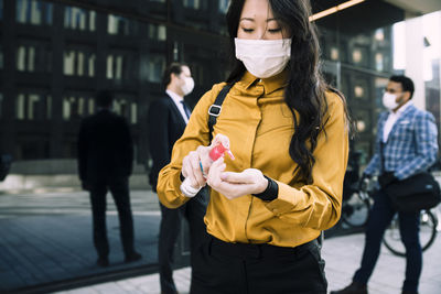 Businesswoman using hand sanitizer