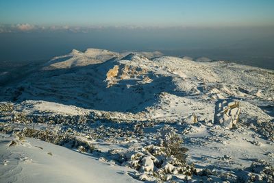 Aerial view of snow covered mountains against sky