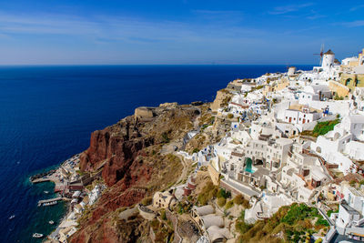 High angle view of townscape by sea against sky