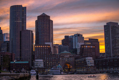 Skyscrapers in city at sunset