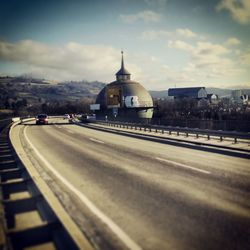 Road in city against cloudy sky