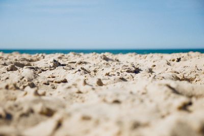 Surface level shot of beach against sky during sunny day