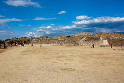 People at old ruins against blue sky