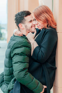 Side view of couple romancing while standing outdoors