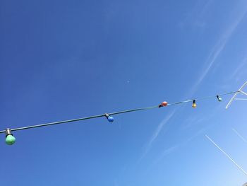 Low angle view of light bulbs against blue sky