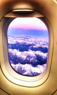 Cropped image of airplane wing over mountains