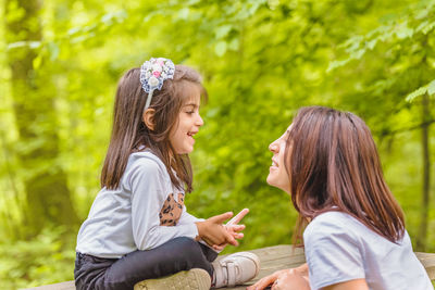 Side view of a smiling girl sitting outdoors