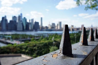 Close-up of metallic structure against buildings in city