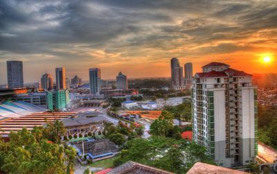 View of cityscape against cloudy sky during sunset