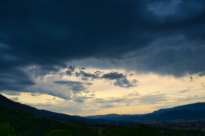 Scenic view of silhouette mountains against dramatic sky