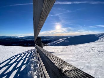 Snow covered land against blue sky