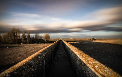 Retaining wall against sky during sunset