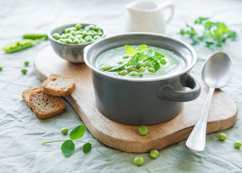 Fresh green pea soup bowl on gray concrete background