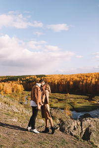 Happy people in love are travel hike in nature in the autumn forest. romantic trip to countryside