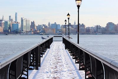 View of pier in city against sky