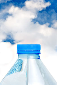 Close-up of blue bottle in container against cloudy sky