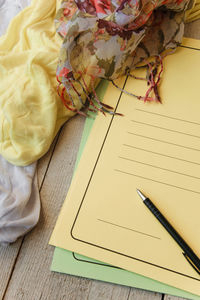 Close-up of files and scarf on table