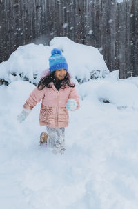 Rear view of woman standing on snow covered field