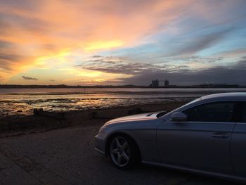 Car on road against sky during sunset