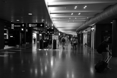 People walking in illuminated corridor