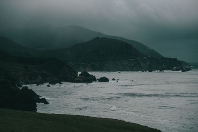 Scenic view of sea and mountains against sky