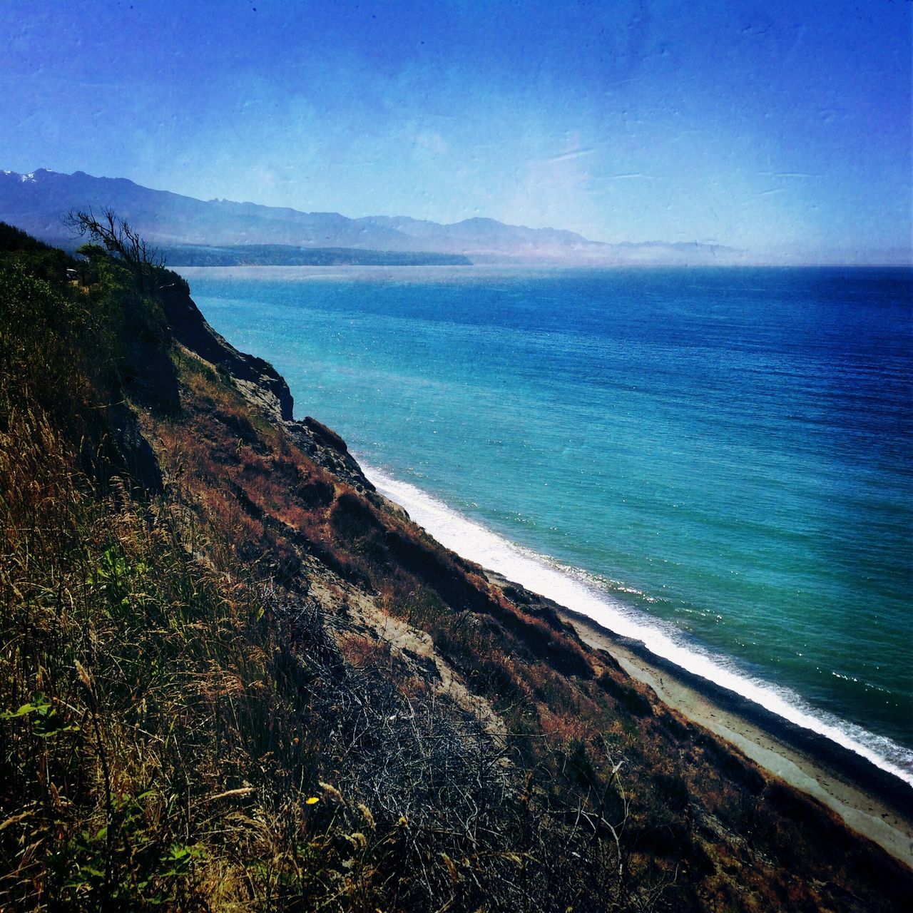 sea, water, tranquil scene, beach, scenics, tranquility, horizon over water, beauty in nature, shore, nature, coastline, blue, sand, mountain, sky, idyllic, clear sky, calm, remote, non-urban scene