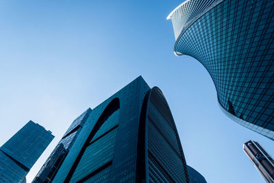 Low angle view of modern buildings against clear blue sky
