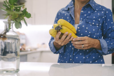 Midsection of woman holding drink on table