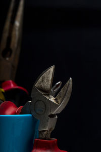 Close-up of metal equipment on table against black background