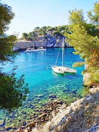 High angle view of sailboats moored on sea against sky