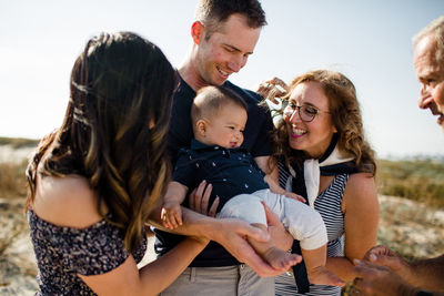 Family smiles as dad holds baby