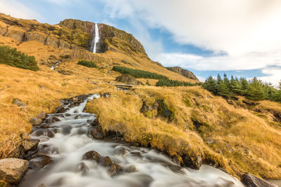 Scenic view of waterfall against sky