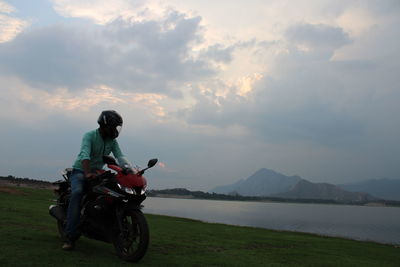 Man riding motorcycle on mountain against sky