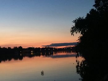 Scenic view of lake against clear sky at sunset