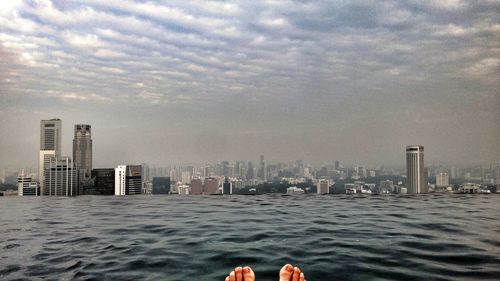 View of cityscape against cloudy sky