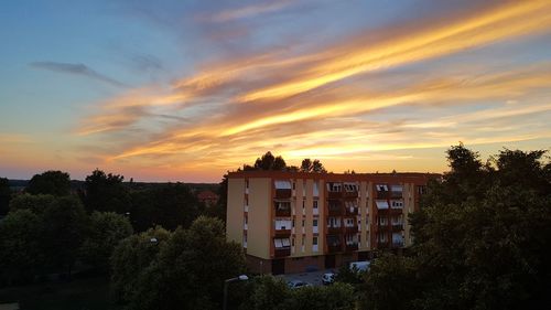 Residential buildings against sky during sunset