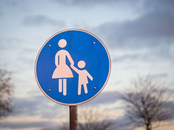 Close-up of road sign against sky