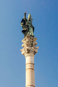 Low angle view of statue against blue sky