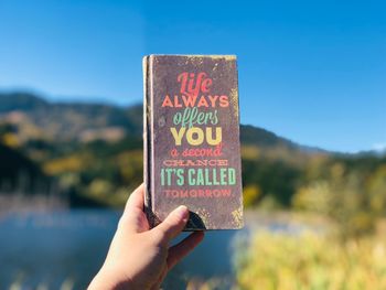 Close-up of hand holding information sign