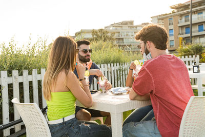 Rear view of people sitting at table