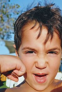 Cropped image of hand punching boy on face