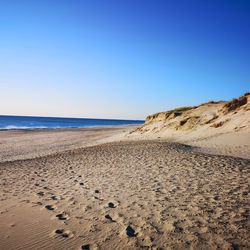 Scenic view of beach against clear blue sky