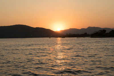 Scenic view of sea and mountains during sunset