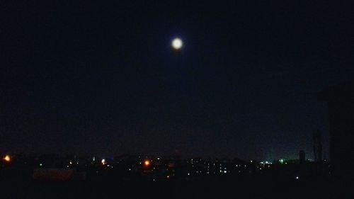 Illuminated city against sky at night