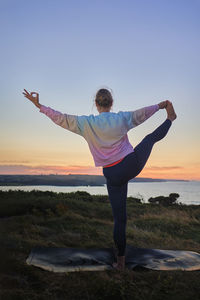 Woman doing yoga in front of the sea, international yoga day concept