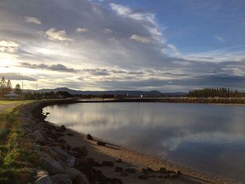 Scenic view of river against cloudy sky
